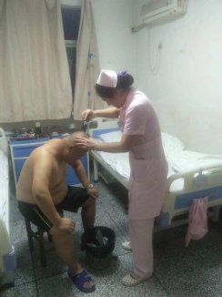 耿瑞玲护士为行动不便的患者理发