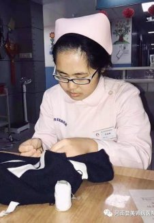 一病区李晓娜护士帮患者把衣服缝好